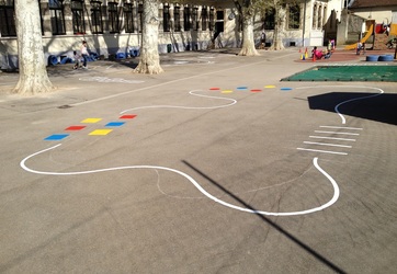 Traçage de jeux éducatifs dans une école : marquage au sol d'un parcours de motricité