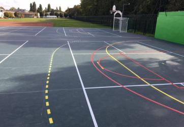 traçage d'un plateau sportif sur sol en caoutchouc mondo. Ponçage préalable des lignes et mise en peinture PU 2 composants.