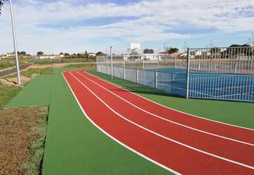 Mise en peinture d'une piste d'athlétisme et coloration de la surface exterieur en vert.