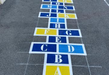 Traçage d'une marelle alphabet dans une école