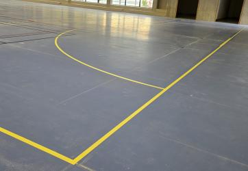 Traçage d'un terrain de handball dans un gymnase sol sportif PVC