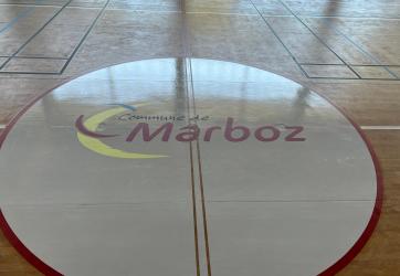 Marquage sur sol sportif d'un logo de la ville sur le rond central du basket ball, en peinture PU