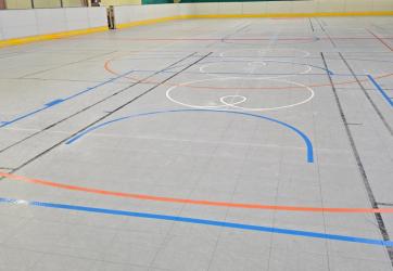 Traçage d'une piste de roller hockey en orange sur dalles plastiques en intérieur en Savoie 74